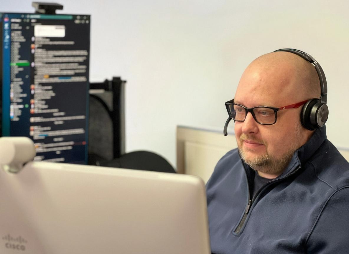 Support engineer wearing a headset at a monitoring workstation in the network operations centre